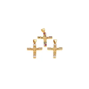 Detalle de colgantes de cruz bañados en oro de 18K con relieve de crucifijo y circonitas