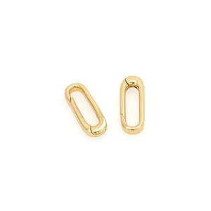 Macro detail of two 18K gold-plated oval carabiner spring clasps with mirror finish