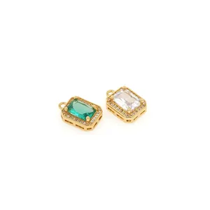 Detailed view of rectangular 18K gold plated pendants with emerald and clear zircon stones