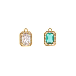 Detailed macro view of gold-plated rectangular emerald and clear zircon halo pendants