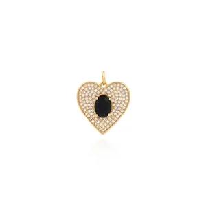 Macro shot of 18K gold heart pendant with black gemstone and micro-pave crystals