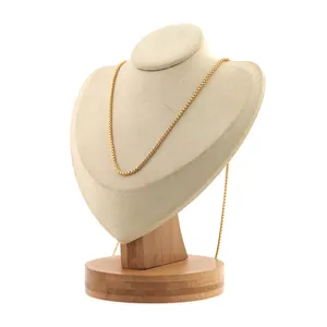 Détail d'un collier chaîne box plaqué or 18 carats sur un support à bijoux minimaliste