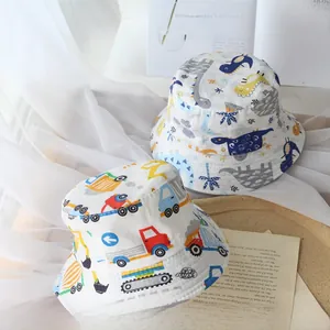 Detail of cotton kids bucket hats featuring cartoon dinosaur and construction vehicle prints