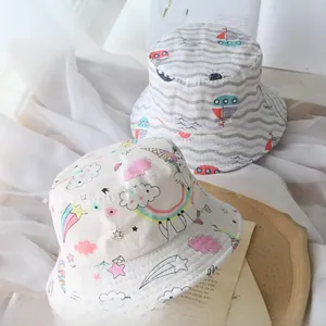 Detailed view of white cotton kids bucket hats with unicorn and sailboat patterns