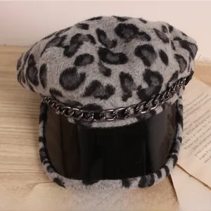 Détail de la casquette léopard grise avec visière en similicuir et chaîne décorative