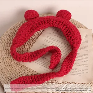 Detail of red knit headband for kids featuring cute animal ears and long woven straps