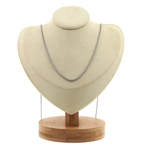 Détail d'un collier chaîne box argenté présenté sur un support en velours beige