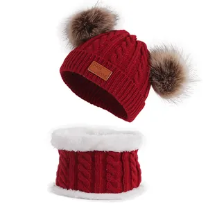 Winter kids knitted hat and scarf set with double faux fur pom-poms in dark red color