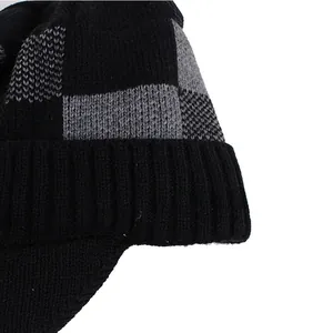 Detailed close-up of men's winter knit beanie with black-grey checkerboard texture and brim