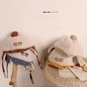 Detail der warmen Ohrenklappenmütze für Kinder mit Teddyvlies und Cord-Bommel-Dekor