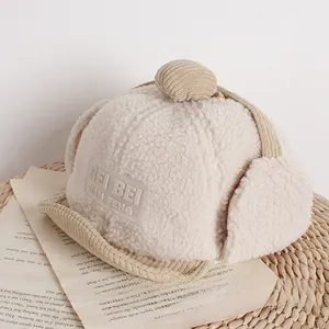 Detailansicht der beigen Teddy-Fleece Kinder-Fliegermütze mit Cord-Schirm und Bommel
