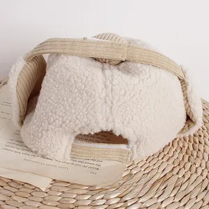 Detailansicht der beigefarbenen Fliegermütze mit Teddyvlies und Bommel-Akzent