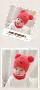 Detail of red knit baby hat with bear embroidery and matching pom-pom neck warmer set