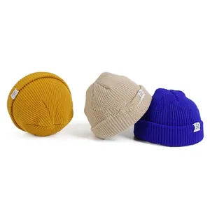 Detailed knit texture of colorful beanies with smiley face woven label for children
