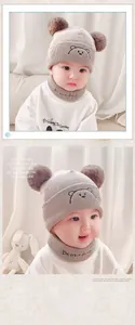 Detailed view of beige baby knit hat with double pompoms and matching bear neck warmer