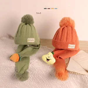 Détails de la maille torsadée et décor de fruits sur l'ensemble écharpe et bonnet enfant
