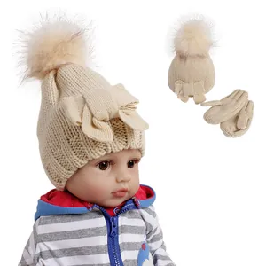 Infant winter knit hat and mittens set with faux fur pom pom and bow in beige color
