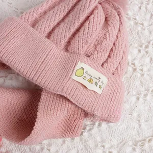 Détail de bonnet en tricot rose avec étiquette tissée Happy every day décorative