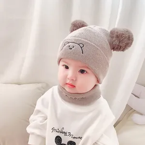 Cute beige baby knitted hat and scarf set with brown pom-poms and bear embroidery