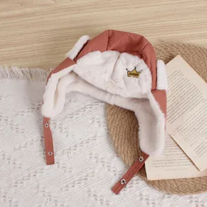 Detail of the thick white faux fur lining and warm crown embroidery on the kid's pilot hat