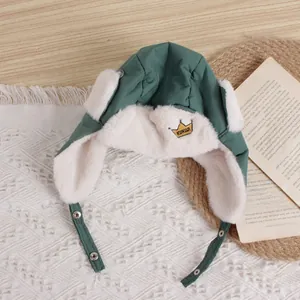 Detail of baby winter pilot hat in dark green featuring crown embroidery and warm faux fur lining