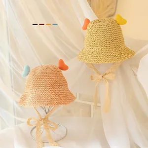 Detail of straw sun hats with heart accents and lace bow straps for kids beach sun protection