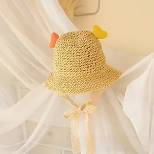 Detail of kids straw sun hat featuring colorful wing accents and delicate lace tie straps