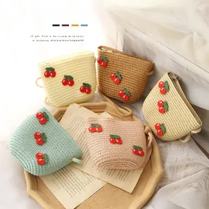 Close-up of cute children's straw bags with cherry embroidery in five pastel colors