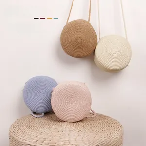 Détail de sacs à bandoulière ronds en paille pour filles en marron, beige, bleu et rose