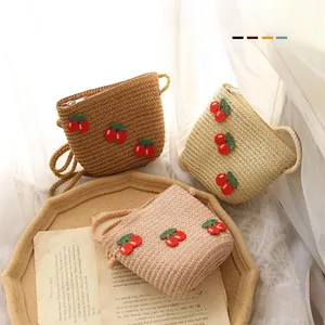 Detail of baby straw bags featuring handmade 3D cherry accents in three soft colors