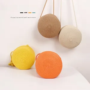 Détail de quatre sacs ronds en paille colorés pour enfants avec texture en spirale