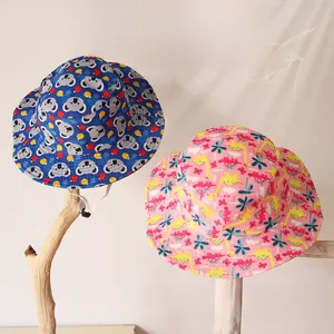 Détail de chapeaux de soleil pour enfants avec motifs koala et dinosaure et cordon réglable