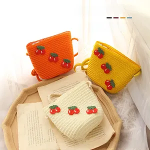Detail of straw woven bags for kids featuring handmade 3D red cherry decorations