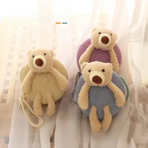 Détail d'un ours en peluche sur un mini sac en paille pour enfants avec fermeture éclair