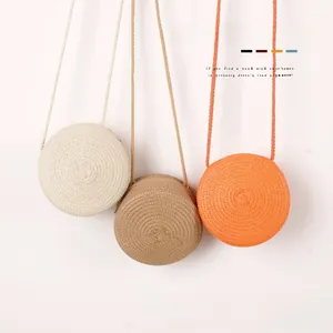 Détail de sacs bandoulière ronds en paille pour filles en beige, kaki et orange vif