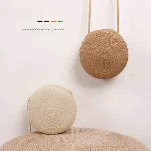 Détail de sacs à bandoulière ronds en paille pour bébés en crème et kaki tressés