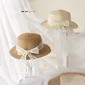 Détail du tissage fin en paille et du ruban en dentelle blanche sur chapeau enfant
