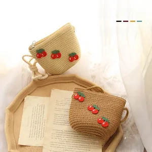Detail of cute cherry straw bags in beige and brown with zipper and cotton rope strap