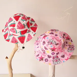 Détail de chapeaux de soleil pour enfants avec motifs pastèque et princesse et cordon réglable