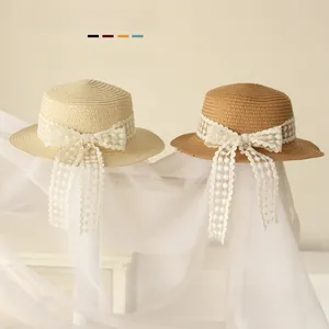 Détail de chapeaux de paille pour bébé avec nœuds en dentelle et broderies florales