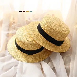 Detailed view of woven straw sun hats with black decorative bands on a wooden background