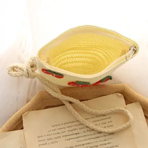 Detailed macro view of cream woven cherry mini bag with silver zipper and long shoulder strap