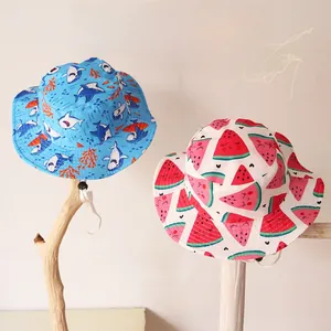 Détail de chapeaux soleil pour enfants avec motifs requin et pastèque et mentonnière