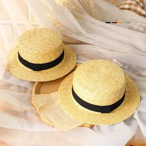 Detail of woven straw texture on kids sun hats with decorative black ribbons