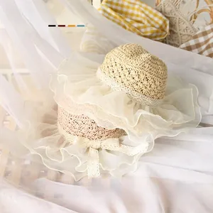 Detail of hand-woven baby straw hats with lace mesh brim and decorative tulle bows
