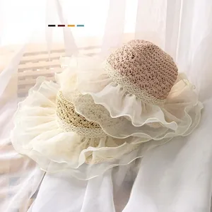Detailed close-up of handmade baby straw sun hat with delicate mesh lace ruffled brim
