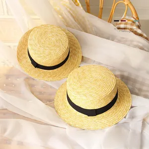 Detailed texture of straw boater hats for kids with black ribbon and bow decoration