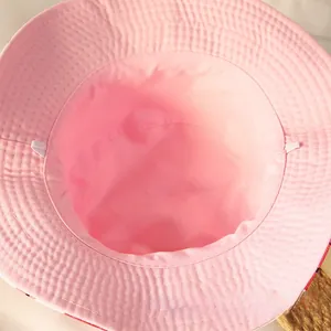 Détail de l'intérieur du chapeau rose avec coutures et sangle élastique coupe-vent