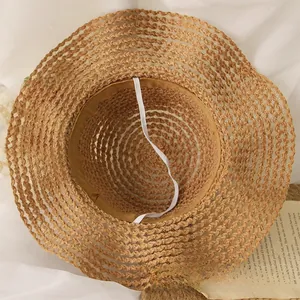 Détail du tissage de paille du chapeau de soleil avec mentonnière élastique réglable