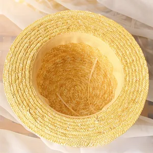 Detail view of woven straw hat interior with sweatband and adjustable elastic strap